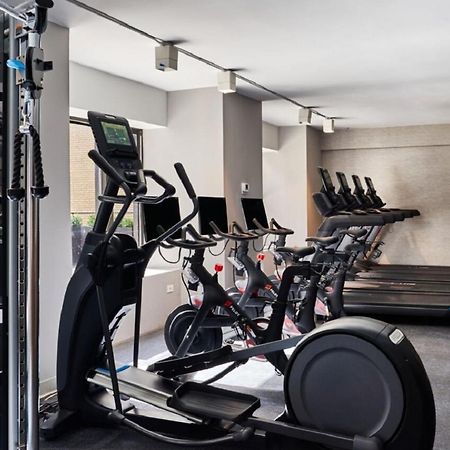 Hotel Park Lane New York Esterno foto The photo shows a gym interior equipped with various fitness machines. On the left, there is a multi-functional weight machine, and next to it, there are several elliptical machines with digital displays. In the background, there are stationary bikes