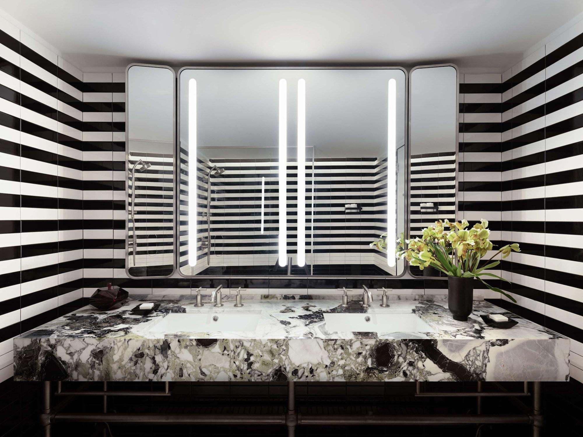 Hotel Park Lane New York Esterno foto The photo shows a modern bathroom featuring a stylish design. The walls are adorned with bold black and white stripes, creating a striking visual effect. In the center, there is a luxurious countertop made of marble, which complements the contemporar