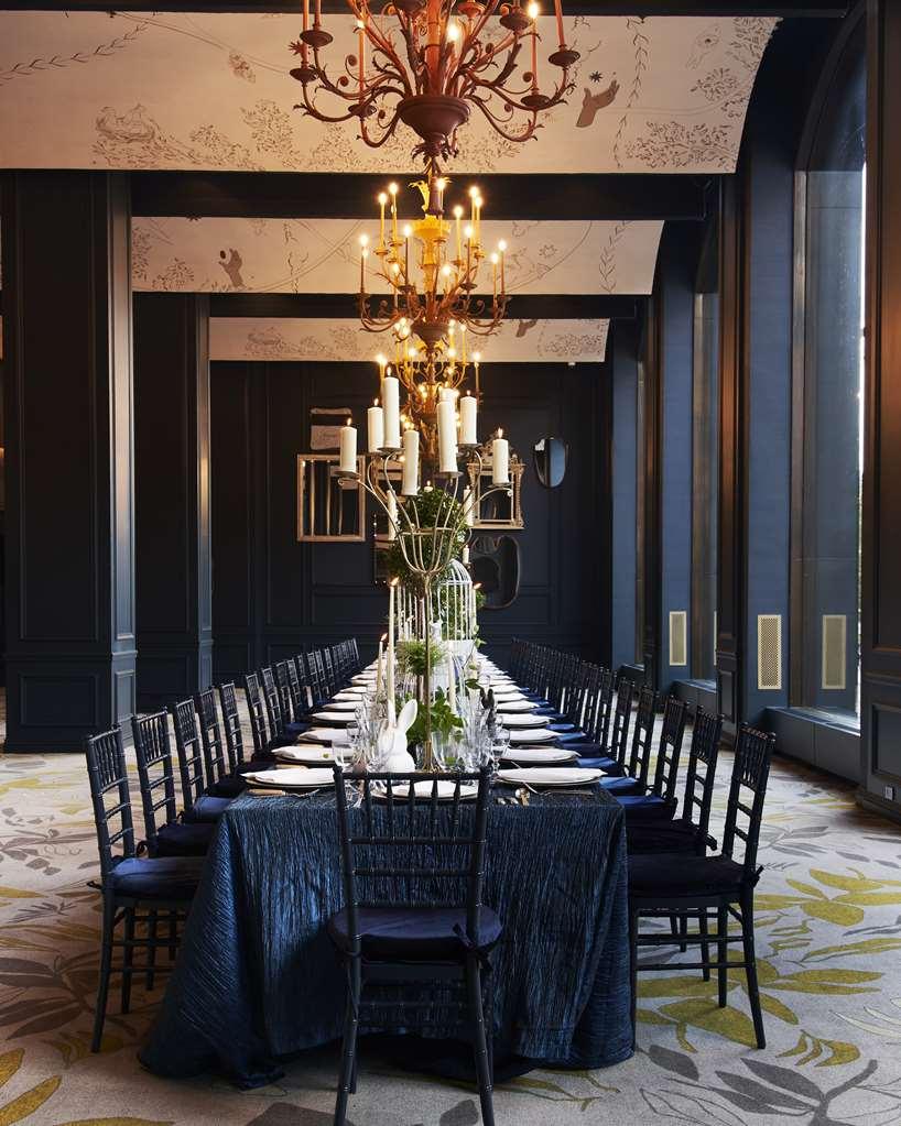 Hotel Park Lane New York Servizi foto The photo depicts an elegant dining room featuring a long table set for a formal gathering. The table is decorated with white plates and silverware, and there is a striking centerpiece with greenery and candles, adding a sophisticated touch. Above th