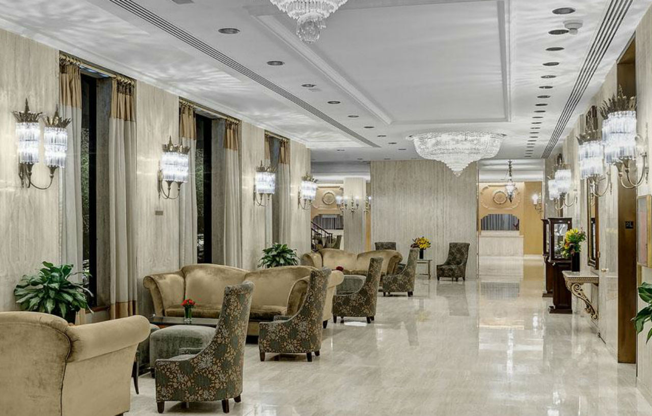 Hotel Park Lane New York Esterno foto The photo shows an elegant hotel lobby characterized by a spacious and modern design. The interior features a polished marble floor and stylish furnishings, including plush chairs and sofas arranged around small tables. Large windows are dressed with